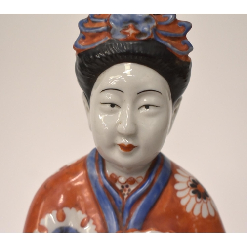 2182 - A LARGE 19TH CENTURY JAPANESE MEIJI PERIOD PORCELAIN FIGURE OF A FEMALE modelled holding a twin hand... 