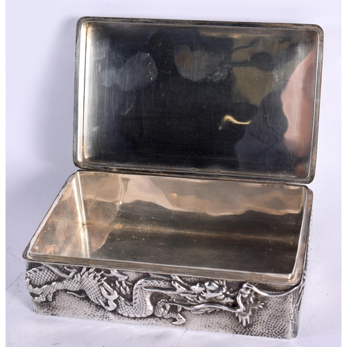 128 - A LATE 19TH CENTURY JAPANESE MEIJI PERIOD EMBOSSED HAMMERED SILVER BOX AND COVER decorated with drag... 