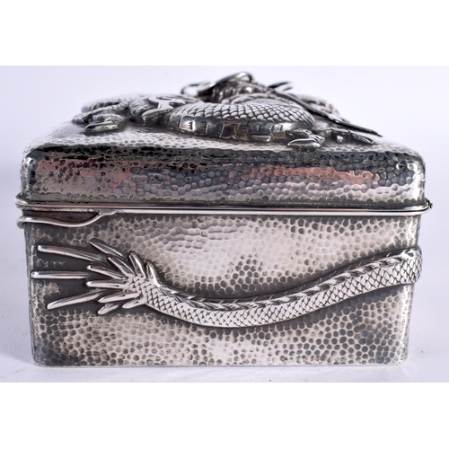 128 - A LATE 19TH CENTURY JAPANESE MEIJI PERIOD EMBOSSED HAMMERED SILVER BOX AND COVER decorated with drag... 