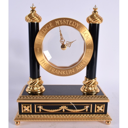 188 - A FRANKLIN MINT FABERGE MYSTERY CLOCK formed with a pearl mounted circular open dial, flanked by wyv... 