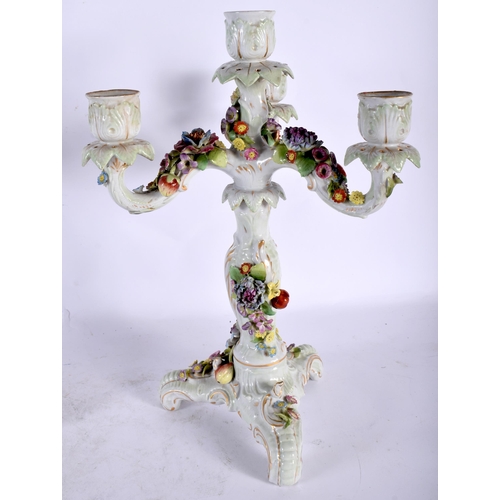 131 - A PAIR OF EARLY 20TH CENTURY CONTINENTAL PORCELAIN TRIPLE BRANCH CANDLESTICKS overlaid with foliage.... 
