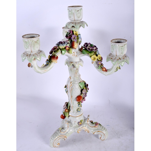 131 - A PAIR OF EARLY 20TH CENTURY CONTINENTAL PORCELAIN TRIPLE BRANCH CANDLESTICKS overlaid with foliage.... 