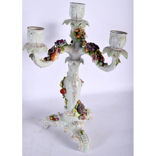 131 - A PAIR OF EARLY 20TH CENTURY CONTINENTAL PORCELAIN TRIPLE BRANCH CANDLESTICKS overlaid with foliage.... 