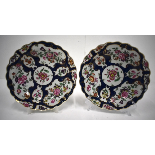 191 - 18th century Worcester pair of plates painted with flowers in gilt panels on a blue scale ground and... 