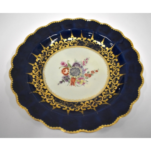 191 - 18th century Worcester pair of plates painted with flowers in gilt panels on a blue scale ground and... 