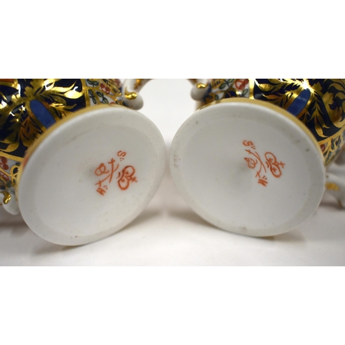 223 - 19th century Derby pair of two handled cups and saucer in an imari pattern, red mark.8cm high