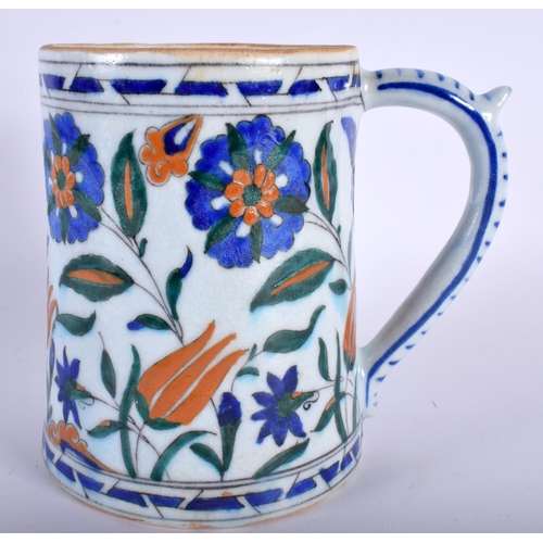 30 - A TURKISH IZNIK MUG painted with flowers. 16 cm high.