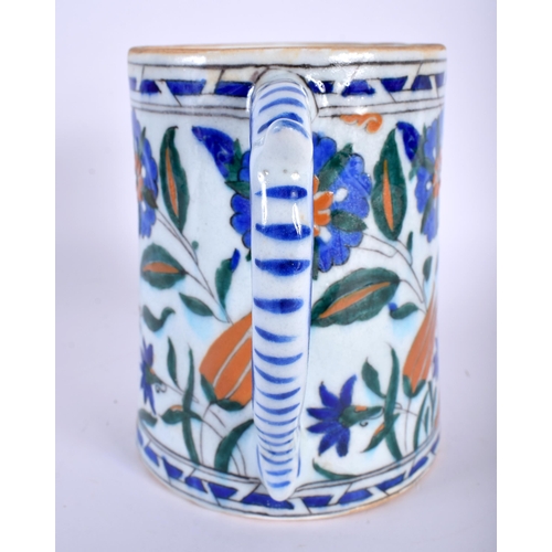 30 - A TURKISH IZNIK MUG painted with flowers. 16 cm high.