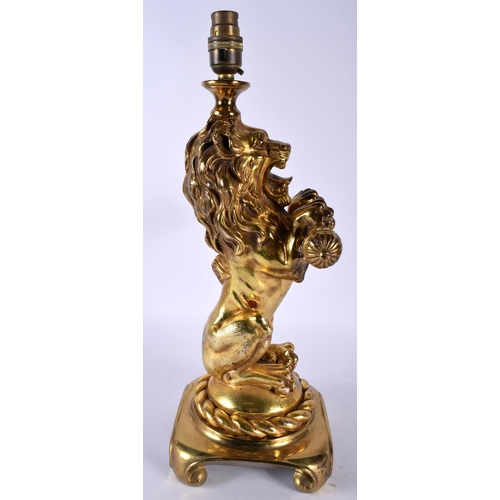 486 - AN ANTIQUE COUNTRY HOUSE GILDED LACQUER LION LAMP upon a gilt metal base. 42 cm x 15 cm.