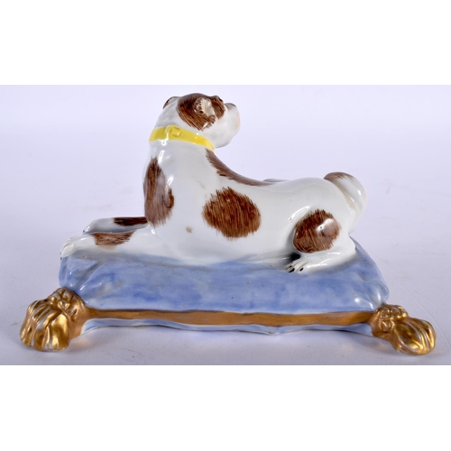 492 - A 19TH CENTURY GERMAN PORCELAIN FIGURE OF A SEATED HOUND modelled upon a lavender painted cushion. 1... 