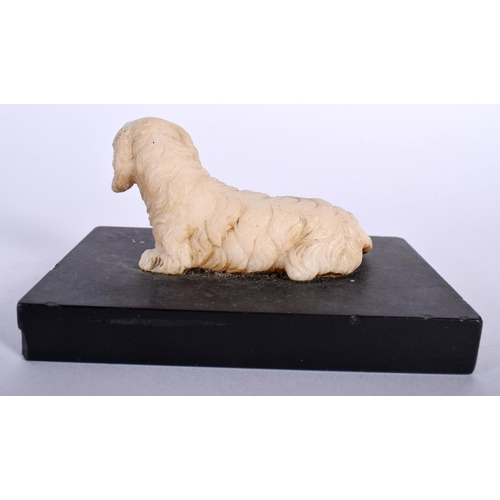 518B - A 19TH CENTURY EUROPEAN CARVED ALABASTER FIGURE OF A SEATED HOUND upon a marble base. 10 cm x 5 cm.