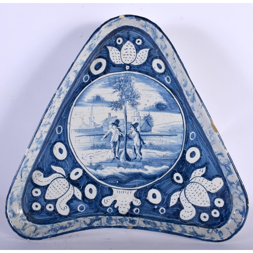 63 - AN UNUSUAL 18TH CENTURY DUTCH DELFT BLUE AND WHITE TIN GLAZED TRIANGULAR DISH painted with figures w... 