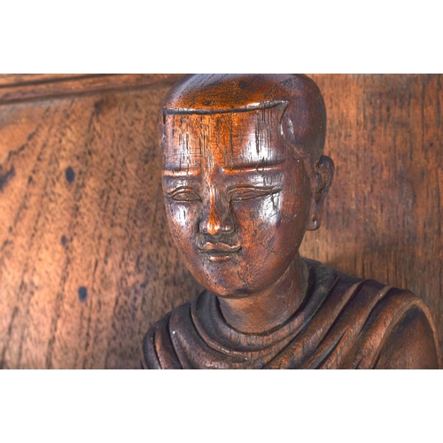 666 - A LARGE 19TH CENTURY INDIAN CARVED WOOD TEMPLE PANEL depicting a buddhistic figure standing upon fla... 