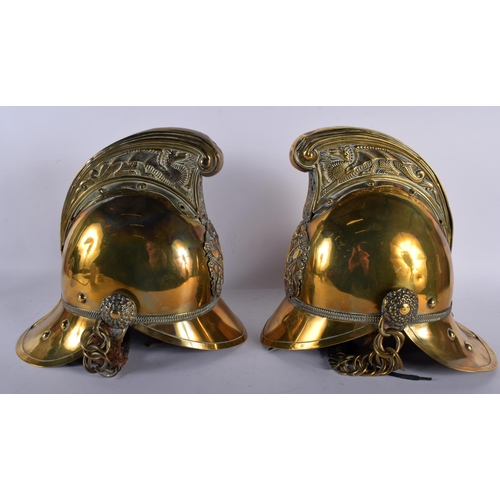 693 - A PAIR OF VICTORIAN BRASS FIREMAN'S HELMETS. 27 cm x 18 cm.