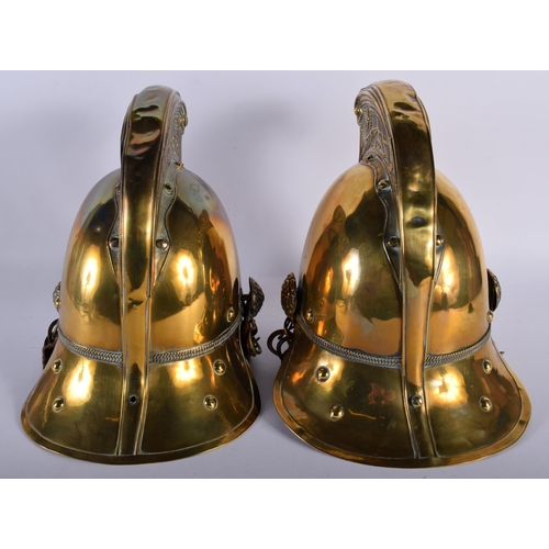 693 - A PAIR OF VICTORIAN BRASS FIREMAN'S HELMETS. 27 cm x 18 cm.