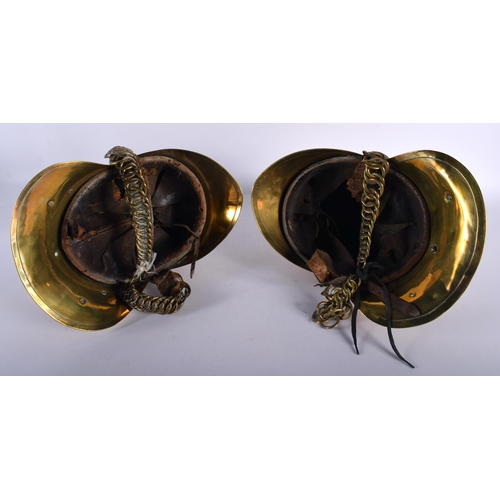 693 - A PAIR OF VICTORIAN BRASS FIREMAN'S HELMETS. 27 cm x 18 cm.