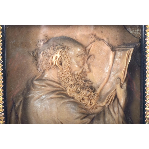 83 - AN 18TH CENTURY CONTINENTAL CARVED WAX PLAQUE OF A MALE modelled in robes reading an open book, cont... 
