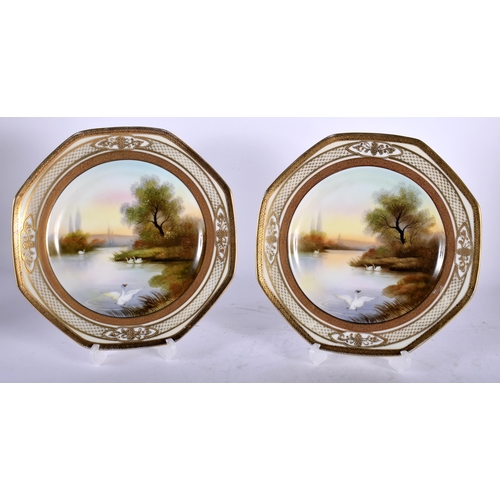 99 - A PAIR OF JAPANESE NORITAKE PORCELAIN OCTAGONAL PLATES painted with swans in a lake. 20 cm wide.