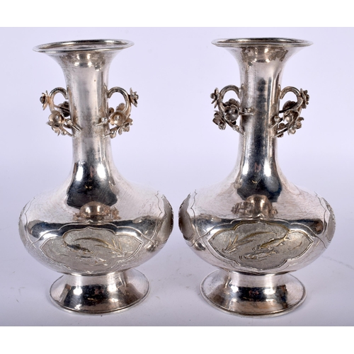 2560 - A PAIR OF LATE 19TH CENTURY CHINESE TWIN HANDLED SILVER VASES decorative with fish and foliage. 500 ... 