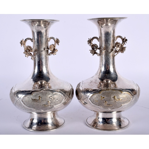 2560 - A PAIR OF LATE 19TH CENTURY CHINESE TWIN HANDLED SILVER VASES decorative with fish and foliage. 500 ... 