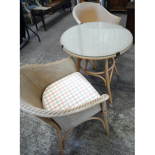 3068 - A WICKER GARDEN SET with two chairs. 77 cm diameter. (3)