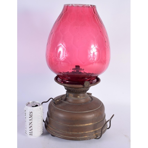 597 - AN ANTIQUE BRASS AND CRANBERRY GLASS OIL LAMP. 44 cm x 20 cm.