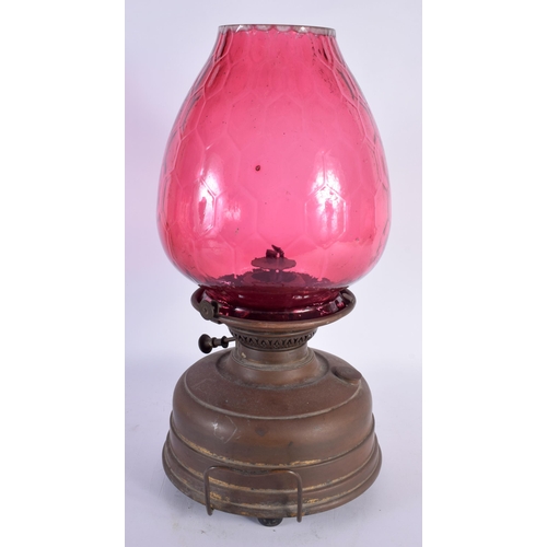 597 - AN ANTIQUE BRASS AND CRANBERRY GLASS OIL LAMP. 44 cm x 20 cm.