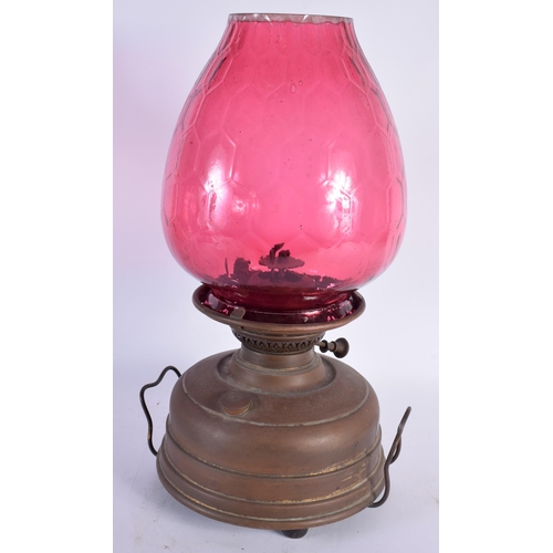 597 - AN ANTIQUE BRASS AND CRANBERRY GLASS OIL LAMP. 44 cm x 20 cm.