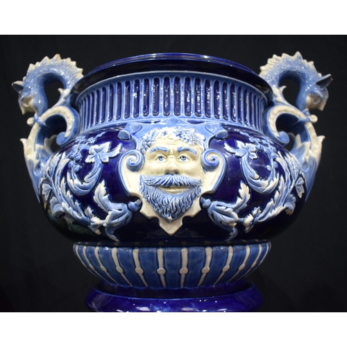 602 - A VERY LARGE ANTIQUE MAJOLICA CONTINENTAL PLANTER ON STAND decorated with bold mask heads. 115 cm x ... 