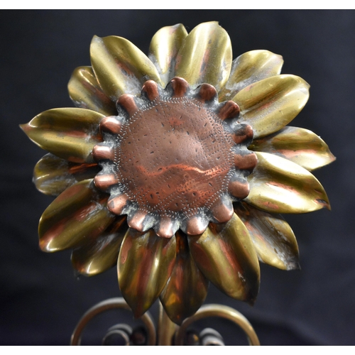 63 - A PAIR OF ARTS AND CRAFTS BRASS AND COPPER SUNFLOWER ANDIRONS of naturalistic form, with scrolling s... 