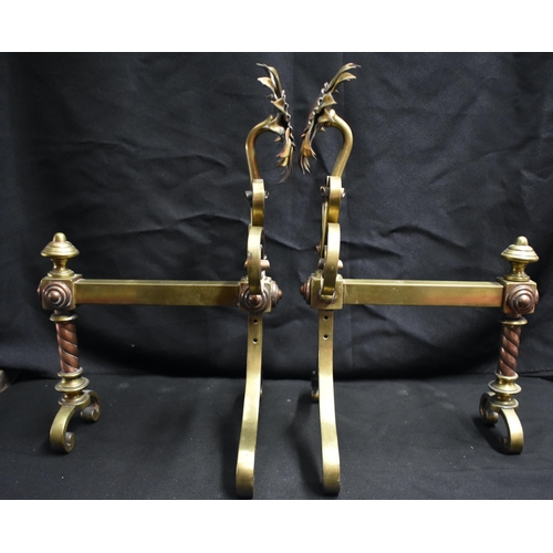 63 - A PAIR OF ARTS AND CRAFTS BRASS AND COPPER SUNFLOWER ANDIRONS of naturalistic form, with scrolling s... 