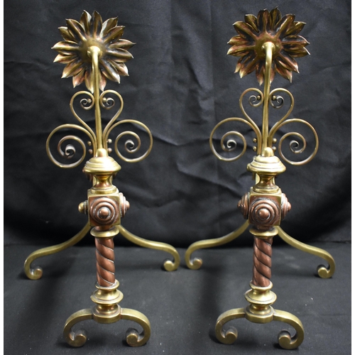 63 - A PAIR OF ARTS AND CRAFTS BRASS AND COPPER SUNFLOWER ANDIRONS of naturalistic form, with scrolling s... 