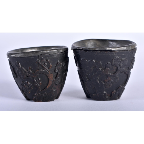 72 - A PAIR OF 17TH/18TH CENTURY CHINESE CARVED COCONUT SHELL CUPS Kangxi/Yongzheng, decorated with trees... 