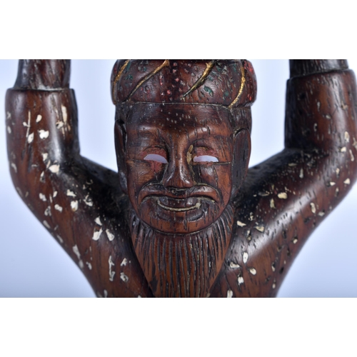 82 - AN 18TH/19TH CENTURY INDIAN CARVED COCONUT FIGURE OF A KNEELING MALE modelled holding aloft a semi c... 