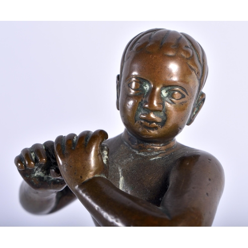 91 - A VERY UNUSUAL 18TH CENTURY INDIAN BRONZE FIGURE OF A EUROPEAN BOY modelled wearing shorts playing a... 