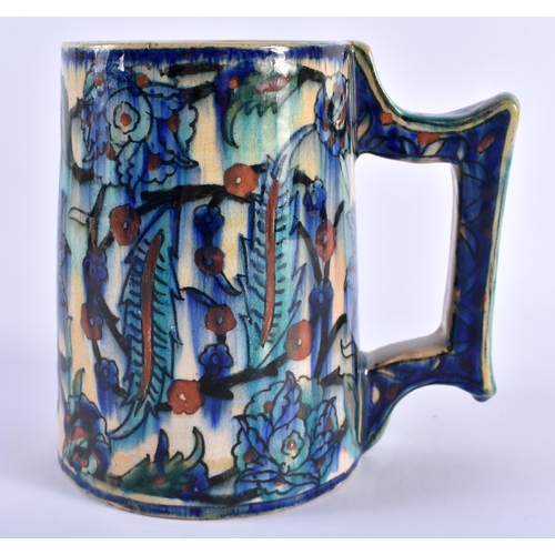 125 - A MIDDLE EASTERN IZNIK FAIENCE POTTERY TANKARD painted with floral sprays. 16 cm x 14 cm.