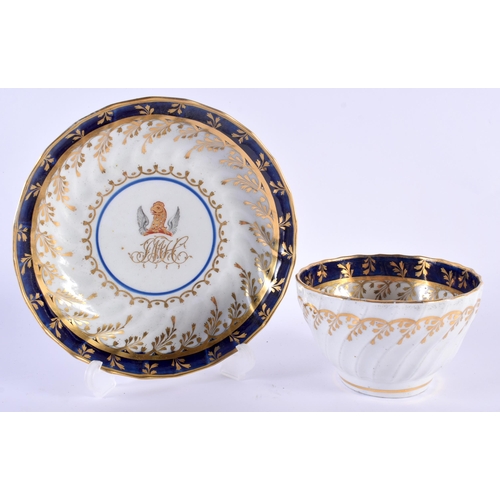 22 - AN OVERSIZED 18TH CENTURY WORCESTER FLUTED ARMORIAL TEABOWL AND SAUCER painted with a central crest ... 