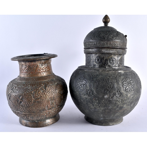 424 - AN EARLY PERSIAN MIDDLE EASTERN BRONZE EWER together with two other similar repousse ewers. Largest ... 