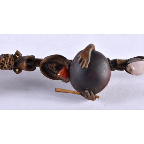 452 - AN UNUSUAL TRIBAL CARVED WOOD AND NUT GEM SET PIPE formed with a grotesque figure. 20 cm long.