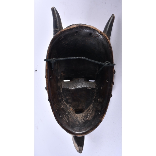 460 - AN UNUSUAL AFRICAN TRIBAL CARVED WOOD LONG NOSED MASK formed with horns and angular motifs. 31 cm x ... 