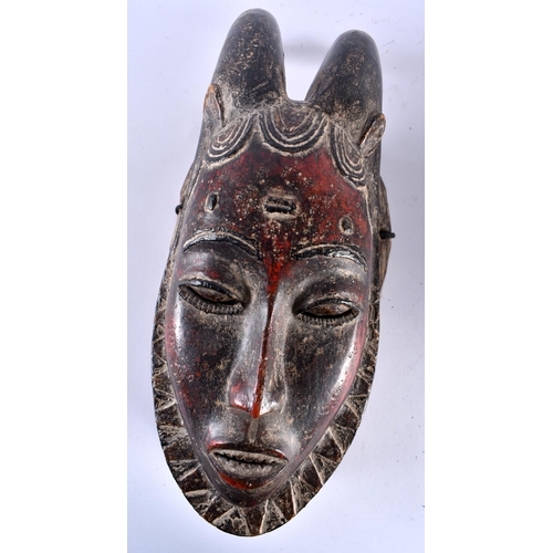 461 - TWO AFRICAN IVORY COAST TRIBAL RED PAINTED GURO WOOD MASKS. Largest 44 cm x 15 cm. (2)