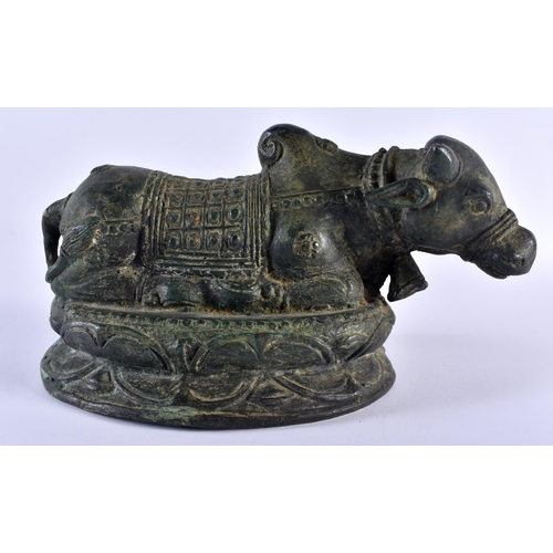 502 - A 19TH CENTURY INDIAN BRONZE FIGURE OF A NANDI BULL modelled recumbent. 18 cm x 12 cm.