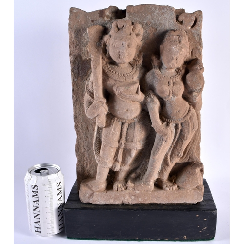 546 - A LARGE EARLY INDIAN VOTIVE CARVED SANDSTONE SHRINE upon a wooden base. 38 cm x 22 cm.