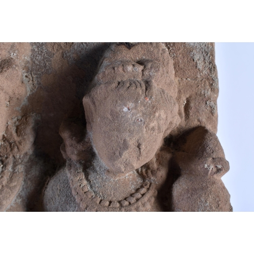 546 - A LARGE EARLY INDIAN VOTIVE CARVED SANDSTONE SHRINE upon a wooden base. 38 cm x 22 cm.