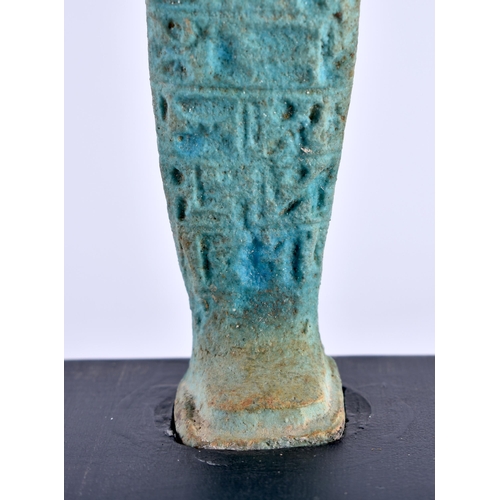 549 - AN EGYPTIAN FAIENCE GLAZED USHABTI FIGURE upon a later ebonised base. Ushabti 11 cm high.