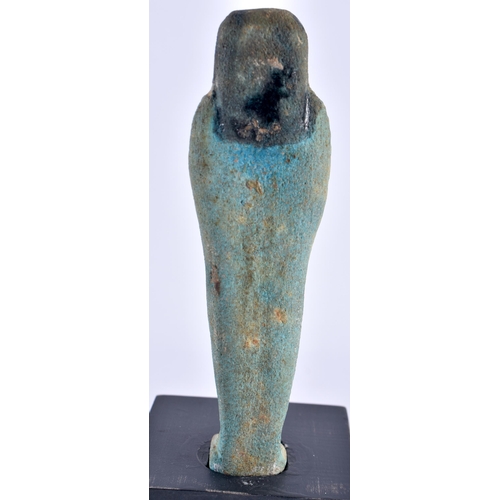 549 - AN EGYPTIAN FAIENCE GLAZED USHABTI FIGURE upon a later ebonised base. Ushabti 11 cm high.