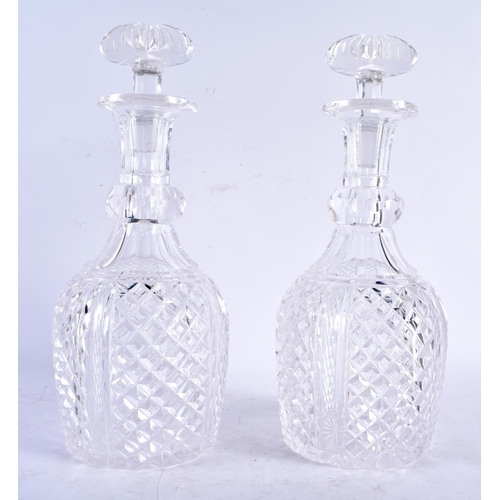 583 - A PAIR OF REGENCY CUT GLASS DECNATERS AND STOPPERS. 28 cm high.