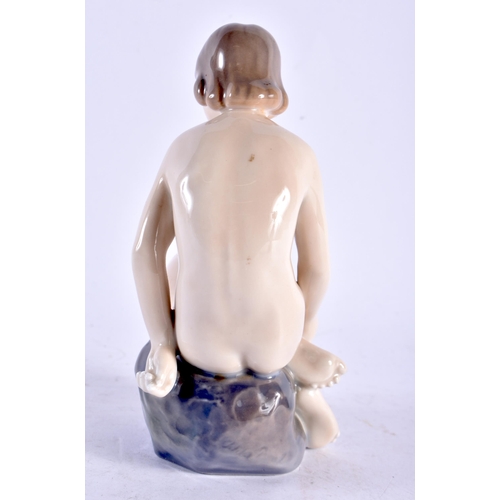 593 - A DANISH ROYAL COPENHAGEN PORCELAIN FIGURE OF A FEMALE. 14.5 cm high.