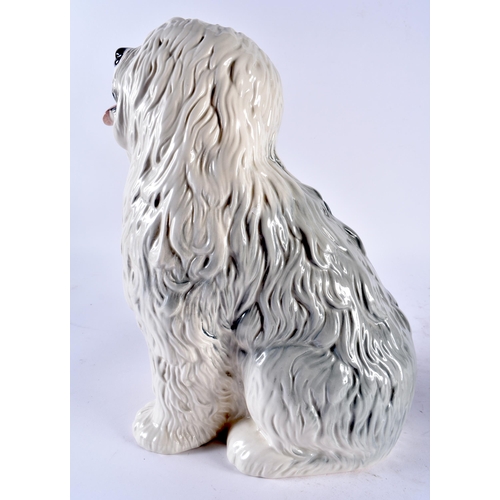 646 - AN ANTIQUE PARIANWARE FIGURE OF A FEMALE together with a Beswick sheep dog. Largest 37 cm high. (2)