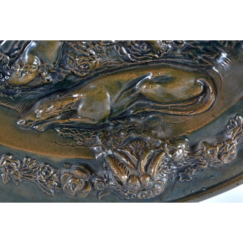 704 - A VERY LARGE 19TH CENTURY CONTINENTAL GREEN GLAZED POTTERY CHARGER depicting classical figures in re... 